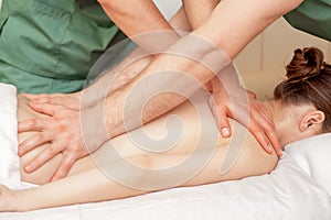 Back massage of woman in four hands