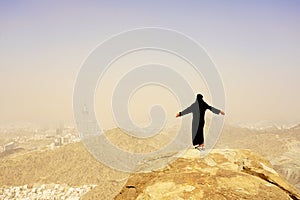 Back natural full body young muslim woman portrait in Ghar Thowr, Mecca, Saudi Arabia, in a sunny and clear sky day photo