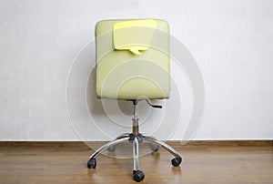 Back of office chair and paper speech bubble on it.What are employees thinking about during the work?