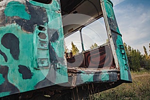 the back of an old abandoned green bus in a field