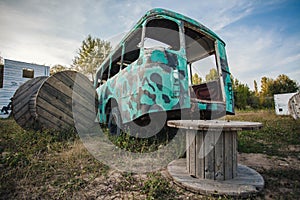 the back of an old abandoned green bus in a field