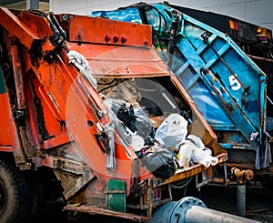 Back of old garbage truck with waste. Urban waste management con