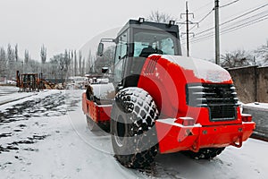 Back of an orange bulldozer with big black wheels at a construction site