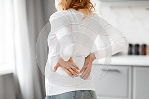 Back pain expression by pregnant woman, cropped