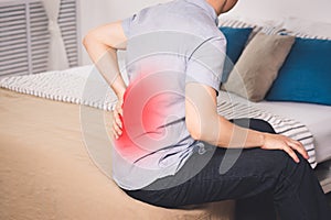 Back pain, kidney inflammation, man suffering from backache at home