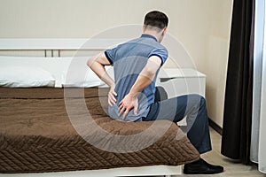 Back pain, kidney inflammation, man suffering from backache at home