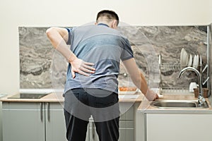 Back pain, kidney inflammation, man suffering from backache at home