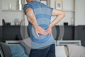 Back pain, kidney inflammation, man suffering from backache at home