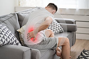 Back pain, kidney inflammation, man suffering from backache at home