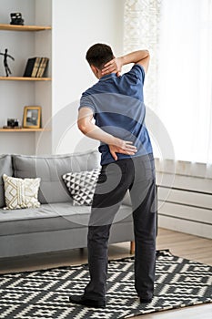 Back pain, man with backache at home