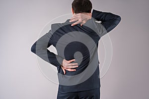 Back pain, office worker with backache on gray background