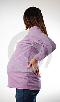 Back pain in a pregnant woman. Load on the spine due to pregnancy. exacerbation of chronic diseases in the back, osteochondrosis photo