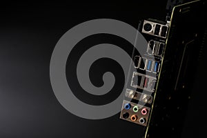 Back panel of a modern computer motherboard with connectors for connecting peripheral devices. Black background. Assembly of a