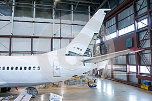 The back of a passenger airplane under maintenance in the hangar