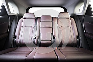 Back passenger seats in modern luxury car, frontal view, red perforated leather