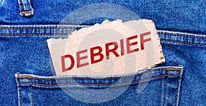 In the back pocket of the jeans there is a brown piece of paper with the text DEBRIEF