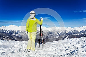 Back portrait of skier woman over mountains