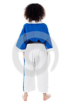 Back pose of a small girl in karate uniform