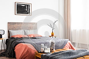Back poster on the white wall of elegant bedroom interior with king size bed with wooden headboard