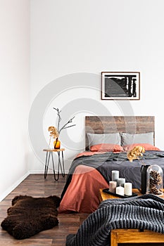 Back poster on the white wall of elegant bedroom interior with king size bed with wooden headboard