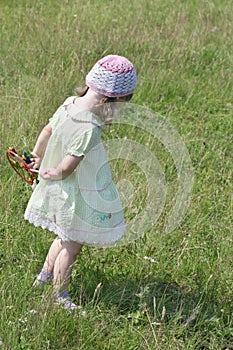 Back of pretty little girl in dress with windmill