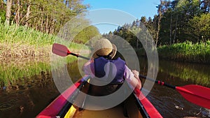 Back Rear View strong caucasian woman rowing Kayaking In Beautiful Lithuania countryside river - Zemeina. Action Camera POV Of