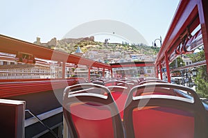 Back of red bus seats with open roof
