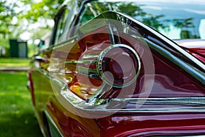 The back of a retro car from the 60s. Rear wing tail unit of red color retro car