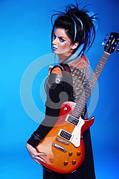Back of Rock emo girl posing with electric guitar on bl