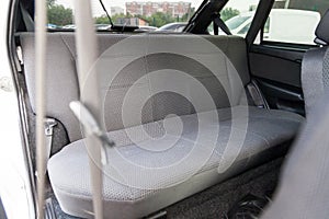 The back row of passenger seats upholstered in gray in an old Russian taxi after a car wash and dry cleaning in auto service