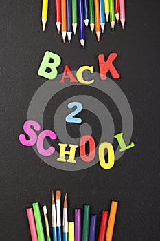 Back 2 school colorful letters and stationery on blackboard background with copyspace for your text. Concept for your