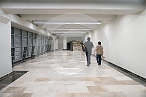 Back shot of two men walking inside a modern corridor in AIFA Airport in Mexico with elegant lights photo