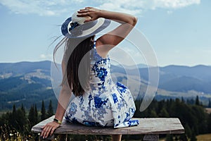 Back shot of young woman in elegant dress admiring breathtaking view