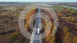 Back Side Aerial view of truck with cargo trailer driving along the highway