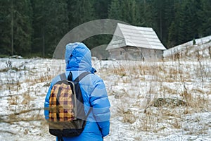 Back side of backpacker man walking to old