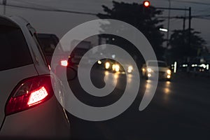 Back side of pick up car gray color on the asphalt road.Cars on the road in traffic junction at night with red light signal.