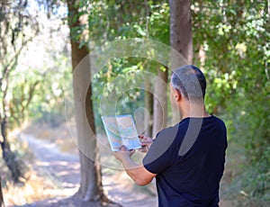 Back side traveler senior man searching right direction on map.