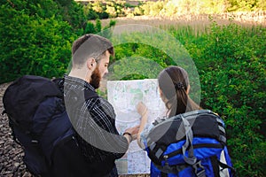 Back side of travelers searching right direction on map, freedom