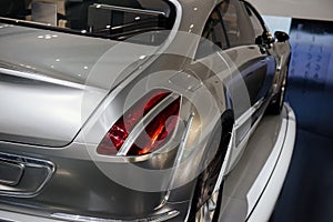 Back, side view of grey cool modern car with right dimensional fire or a rear light , which is divided into a parking