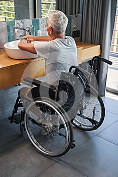 Aging male who lives with disability washing his hands photo