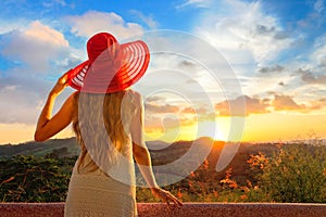 A back side view on a wonderful young woman watching sunset.