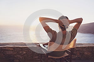 Back side of young man looking at the sea, vacations lifestyle concept