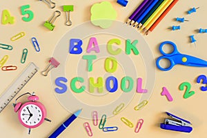 Back to the center of the light background is the inscription Back to School. Around the school and office supplies are