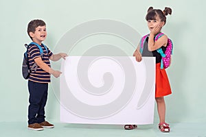 Back to school - advertisements. School Kids with backpacks holding white blank or white card.