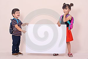 Back to school - advertisements. School Kids with backpacks holding white blank or white card.