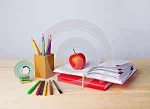 Back to school background with books, pencils and apple over wooden table