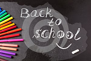 Back to school background with colorful felt tip pens and title Back to school written by white chalk