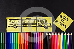 Back to school background with a lot of colorful felt-tip pens and colorful pencils, titles `Back to school`