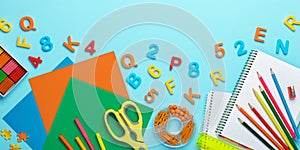 Back to school background. Plasticine, scissors, colored paper for crafts, pencils, notebook, ruler, plastic numbers and letters.