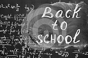 Back to school background with title `Back to school` and math formulas are written by white chalk on the black chalkboard.